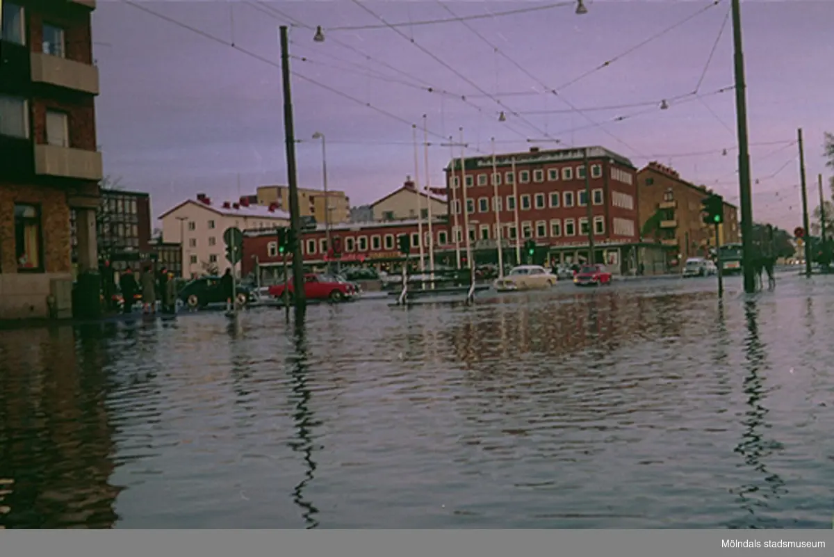Översvämning av Göteborgsvägen vid Tempelgatans mynning, 1960-tal. I bakgrunden ses Folkets hus. Från utställningen, "Mölndals bro - minnen, förändring, framtid".