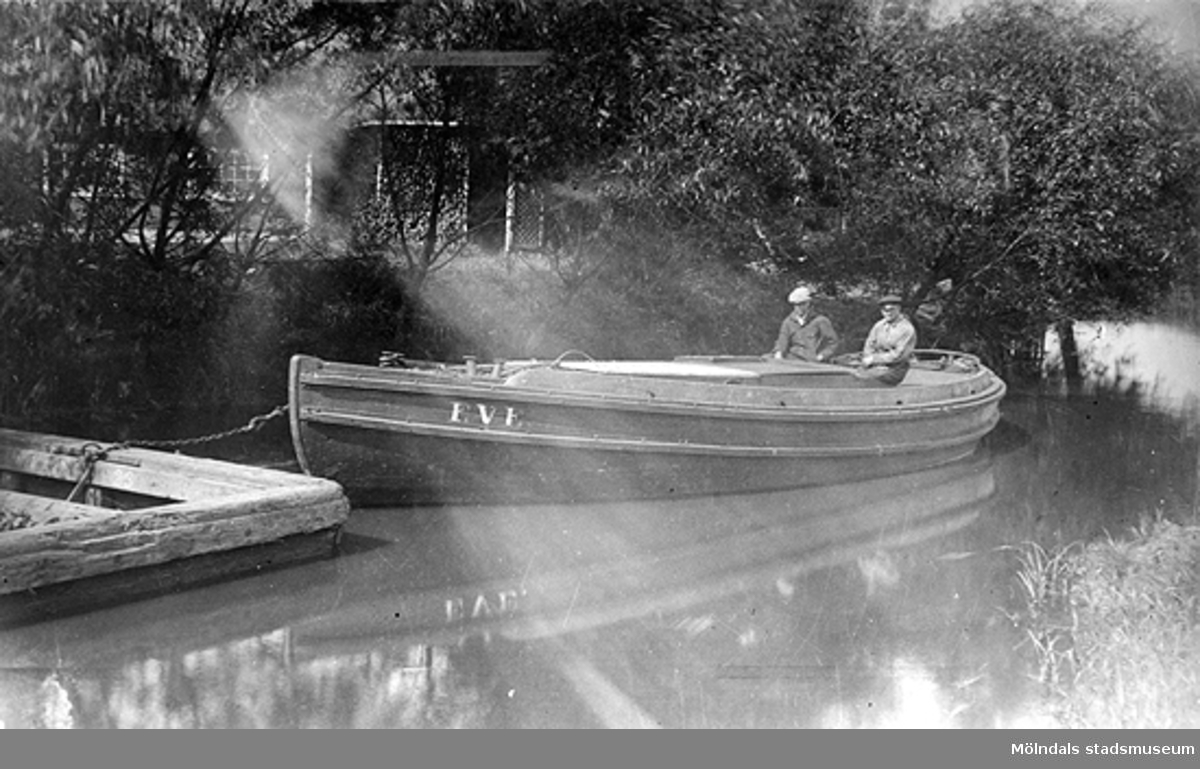 Två män sitter i bogserbåten EVE i Mölndalsån, okänt årtal. Bogserbåten drog kokspråmar.