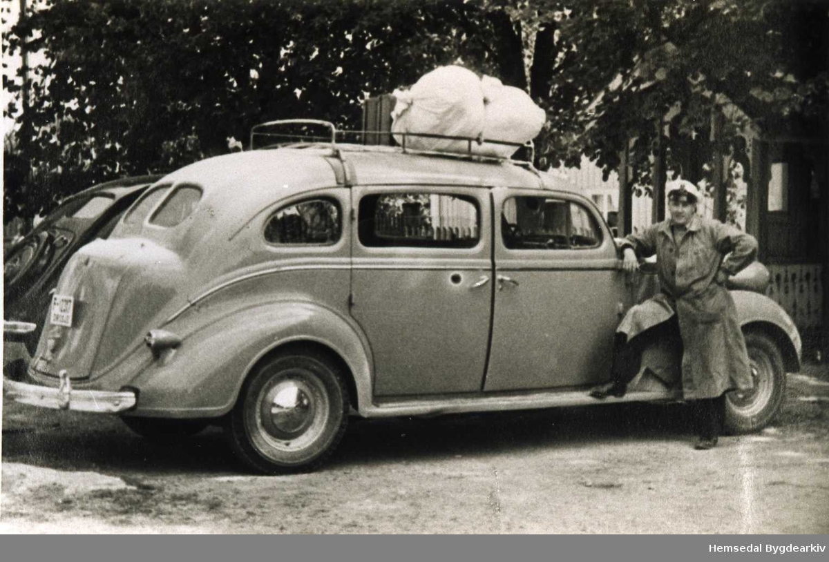 Knut E. Langehaug frå Hemsedal med drosje F12317, ein Chrysler 1937modell med 7-sete, ved Odnes Hotell 1948-1949. Bilen bak Opel Kaptain 1937 mod.