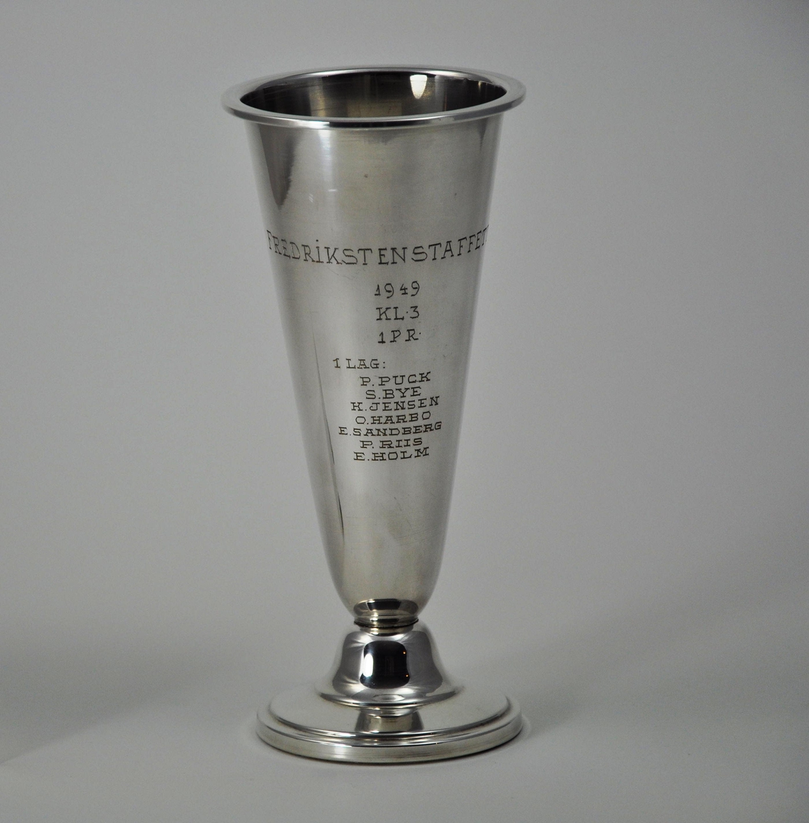 Pokal i sølv for første premie i Fredrikstenstafetten i 1949. Begeret har løsnet fra foten.