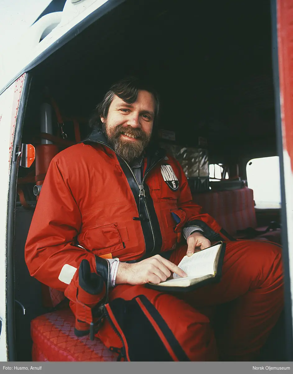 Nordsjøprest Petter Skantes leser fra bibelen i et helikopter.