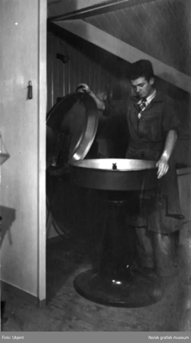 En ung mann med en spesiell maskin, antatt en roterende "slynge" til å belegge sink med  et tynt emaljelag i prosessen med å lage sinkklisjeer. 
Albumtekst: "Thomas (ikke ?uleselig ord?) (Den sidste) 1939"