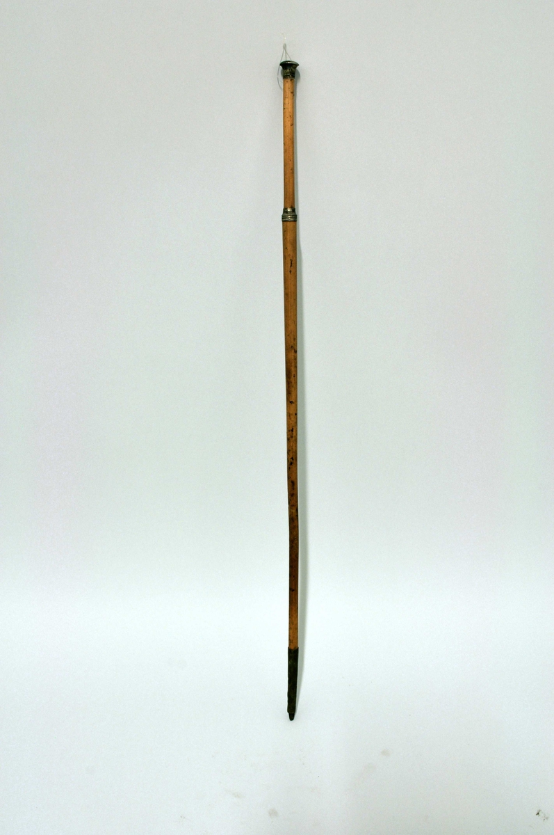 Fra protokoll: Spaserstokk, gul-lakket bambus, sölvknapp-håndtak, messingholk på tuppen m/ jernpigg. L: 91 cm.