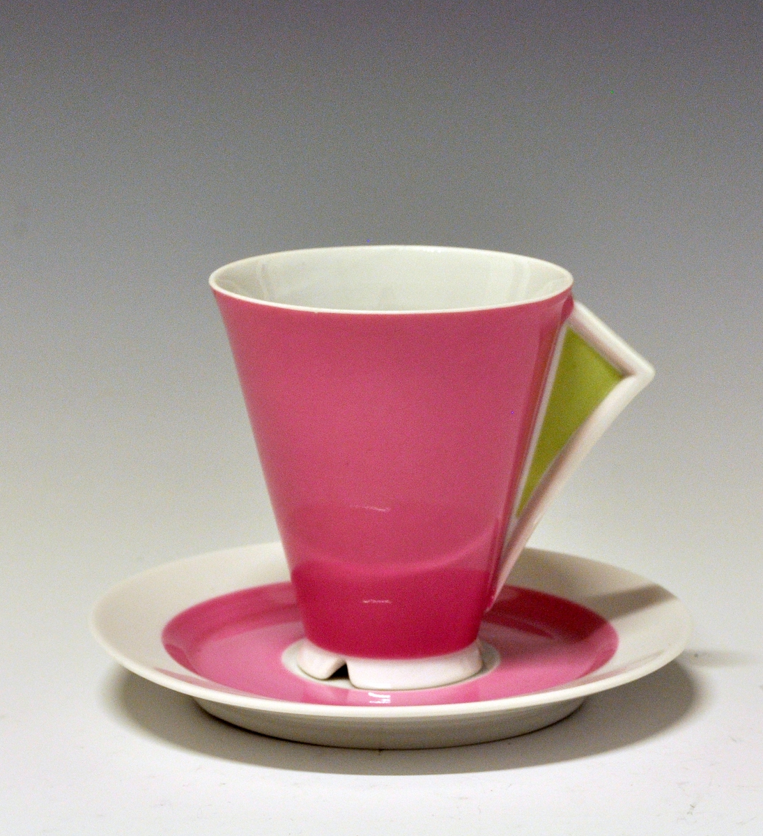 Kaffeskål av porselen, dekorert med et rosa bånd innerst på fanen.
Modell: Style