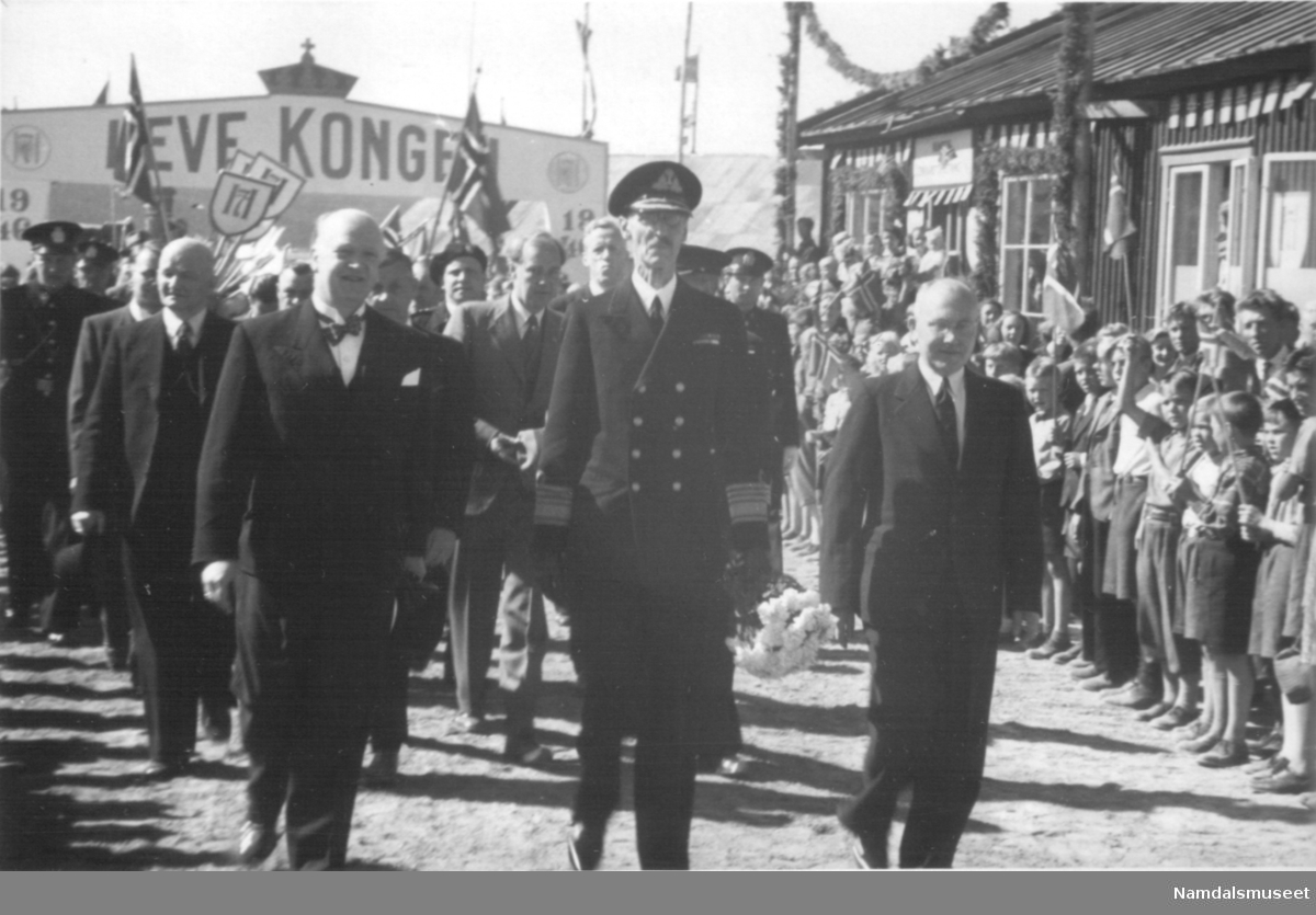 Fra Kongebesøket i 1946. Kongen fremst i prosesjon opp gjennom velkomstportalen.