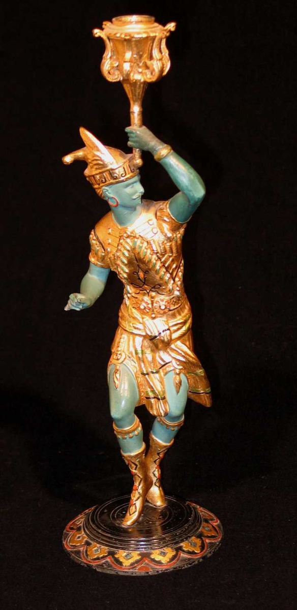 Lysestaken er laget i jern eller bronse. Den forestiller en orientalsk danser som står på et rundt fotstykke. Han holder et skaft som ender i en lysbeholder. Ansiktet og kroppen er malt grønn, mens drakt og sko er gullforgylte.