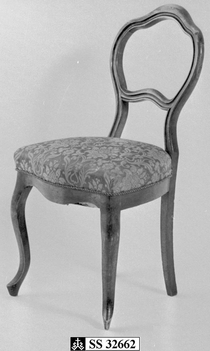 Stolene er i brunbeiset bjørk med mønstret grønt damask-trekk.