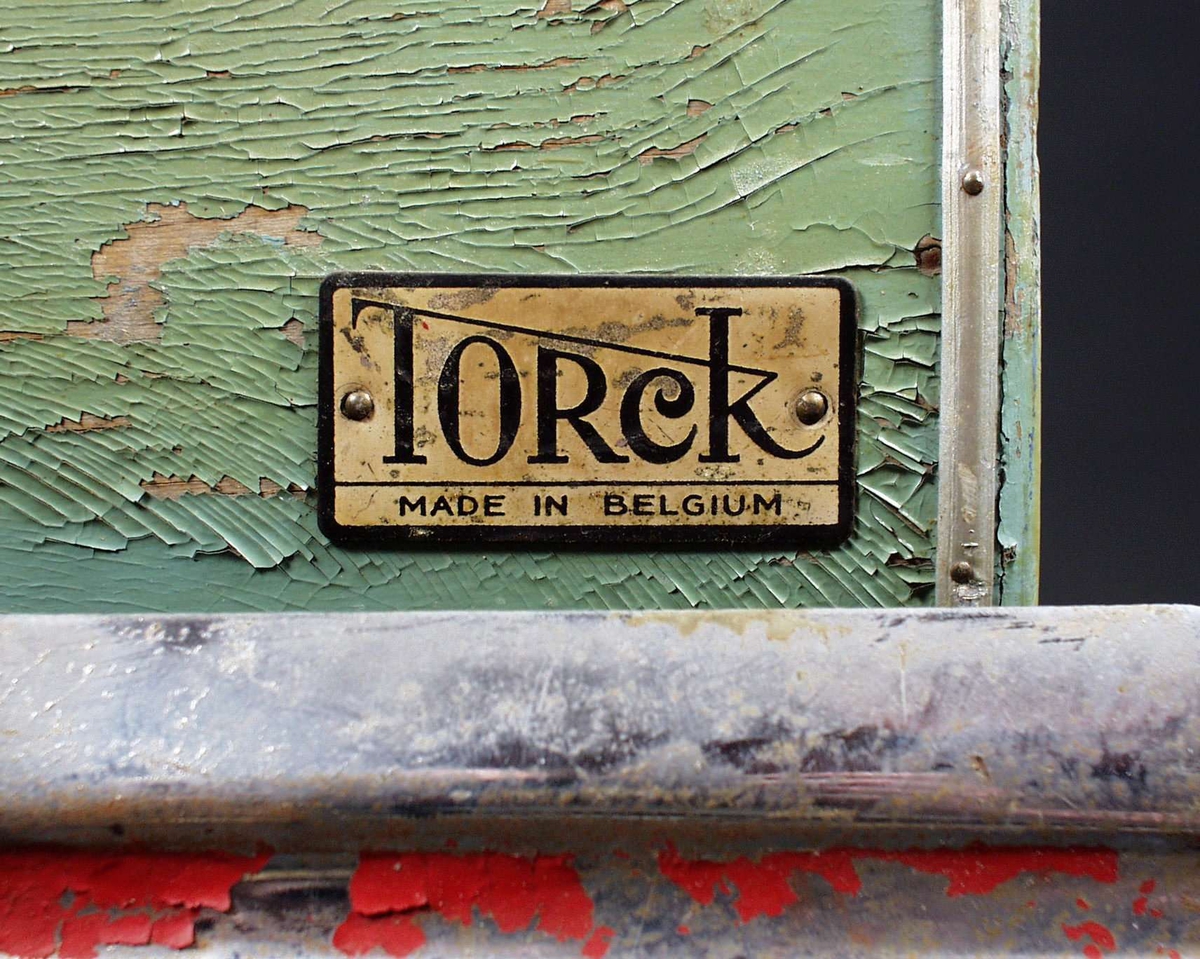 Grønn barnevogn med tilhørende dyne og madrass. Barnevogna har kalesje og skjerm i plastmateriale. Kalesjen er av stoff og har blitt noe slitt. 