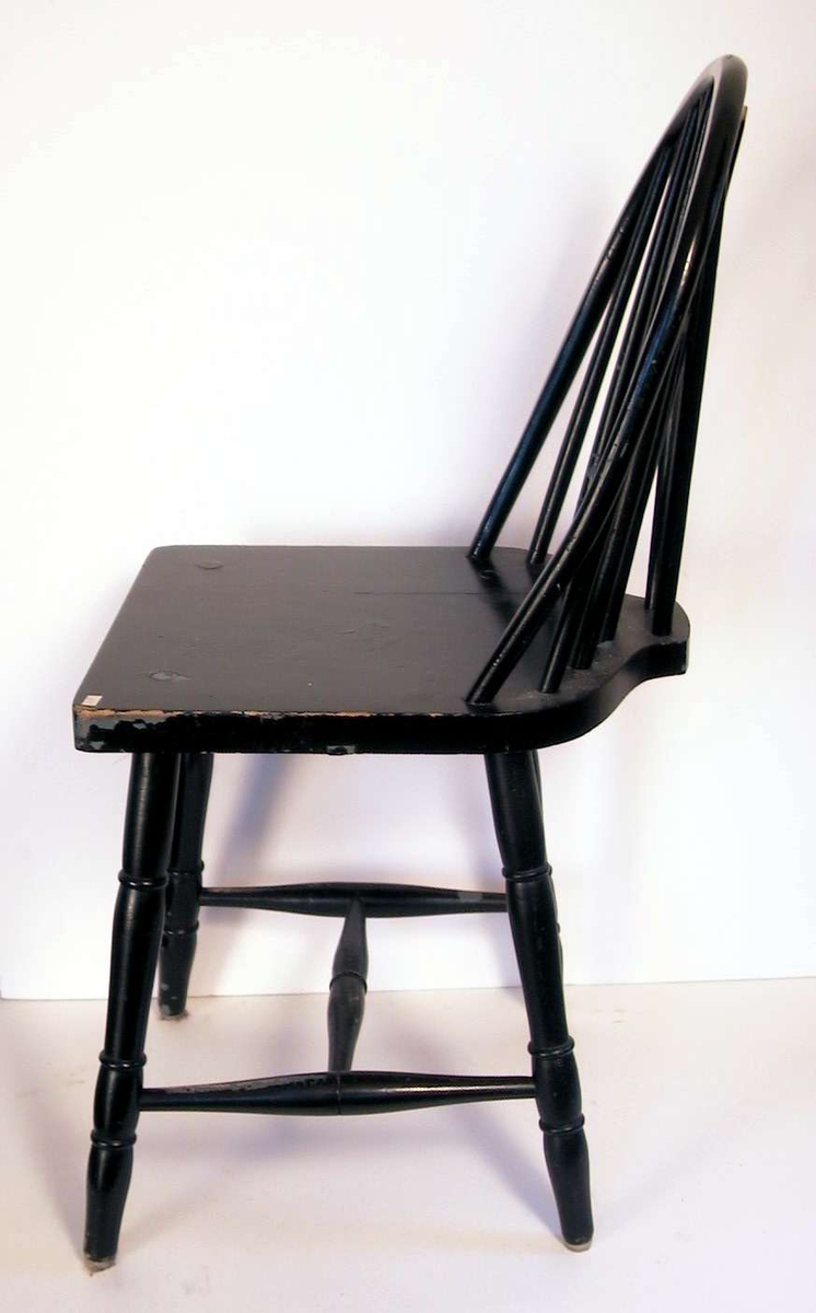 Sortmalt pinnestol med sprosser i ryggen. 