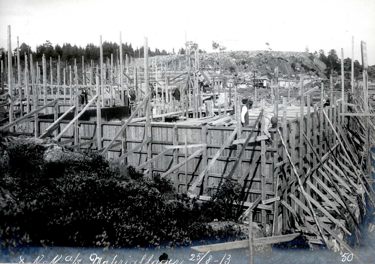 "25/08-1913" Nitriden. Forskalinger og støping av materiallagerbygningen, som også inneholder verksteder og kontorer. I bakgrunnen planert tomt for svovelsyrefabrikk, som ikke ble noe av.