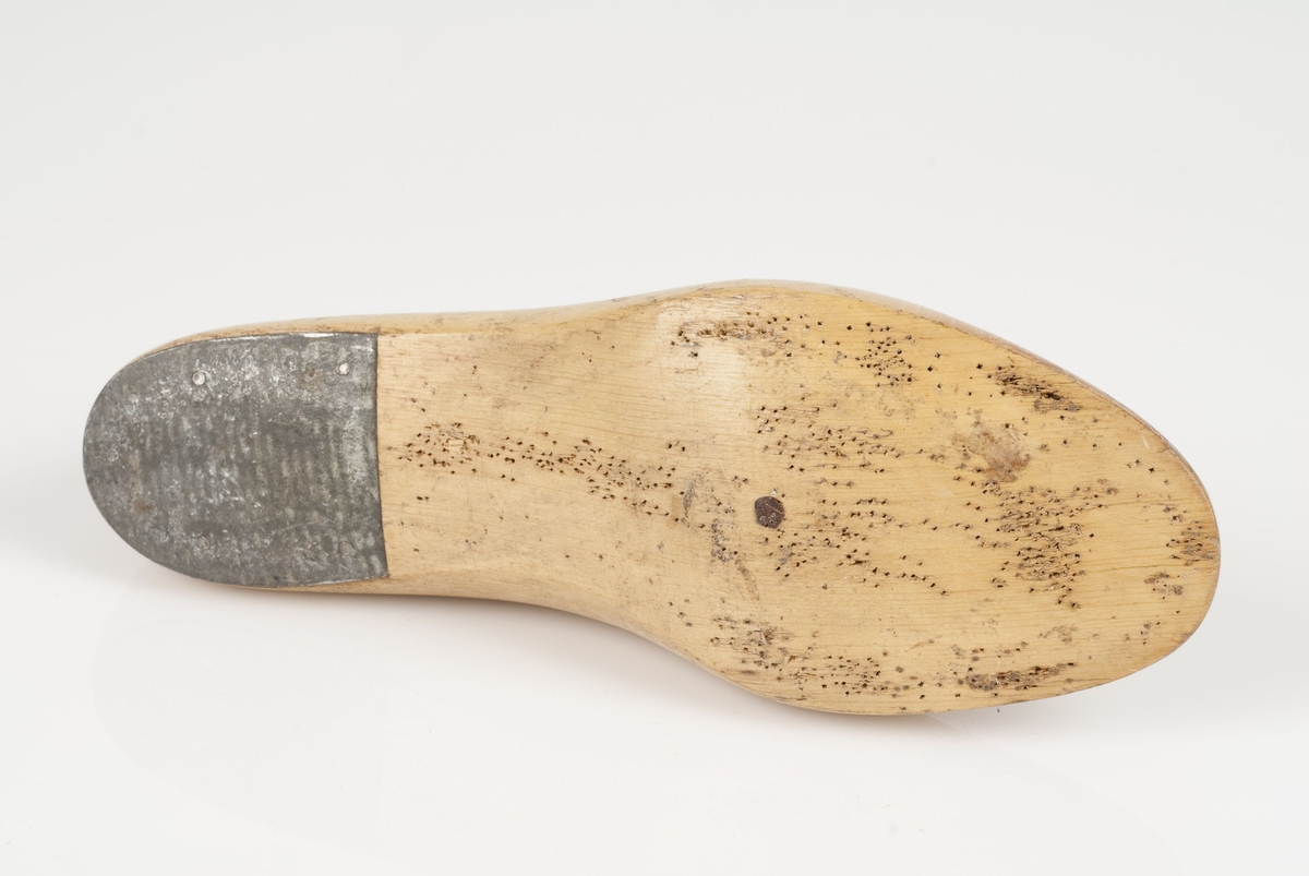 En tremodell i to deler; lest og opplest/overlest (kile).
Høyrefot i skostørrelse 36, og 8,5 cm i vidde.
Lestekam av skinn
Hælstykket av metall.