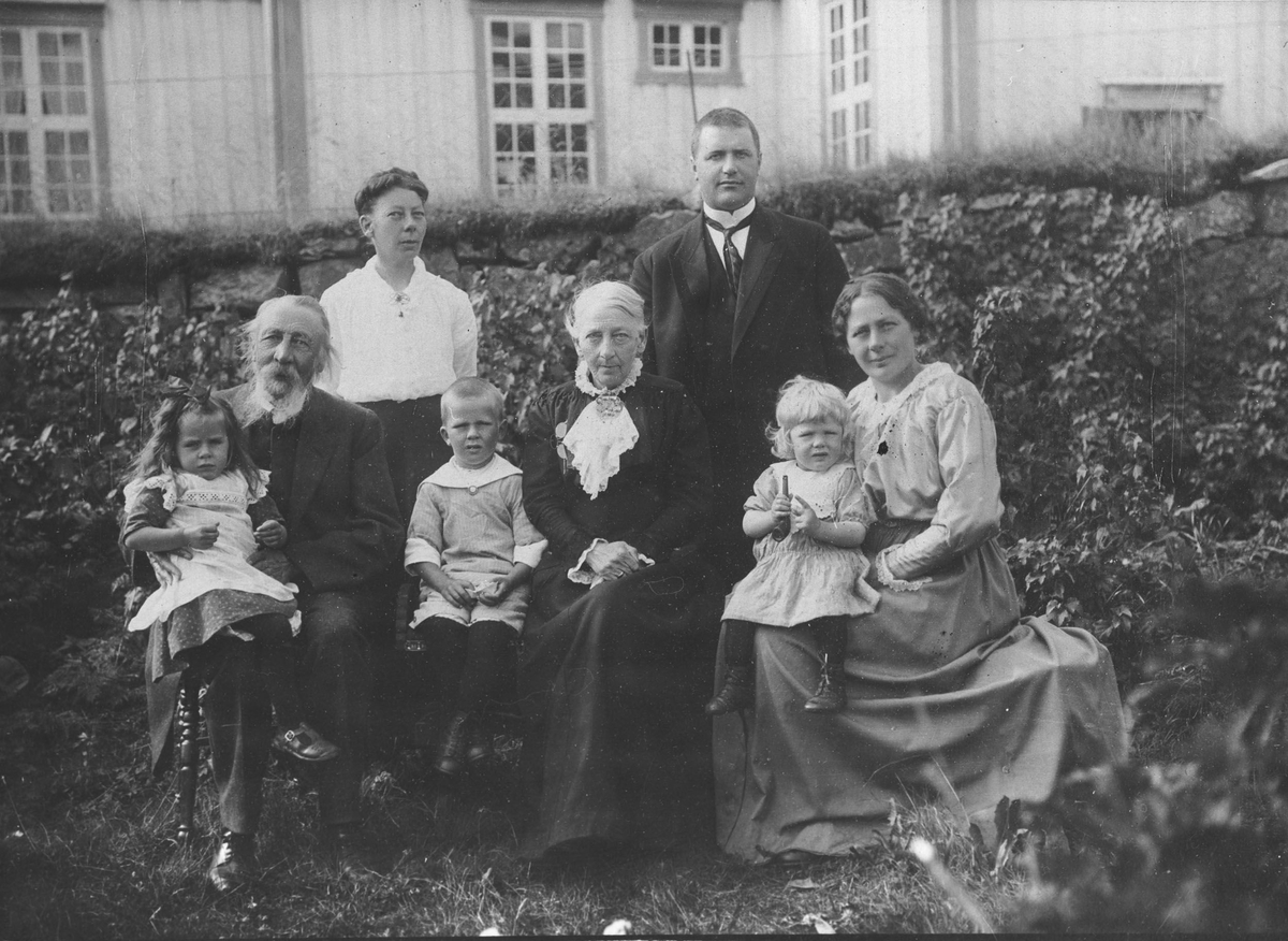 Familegruppe i hagen. Prost August Venaas, kone og døtre