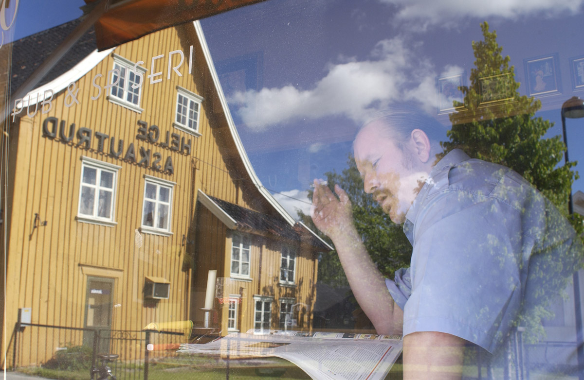 Pubgjest med røyk, øl og avis ses i vinduet til Milde Moses Pub & Spiseri i Drøbak