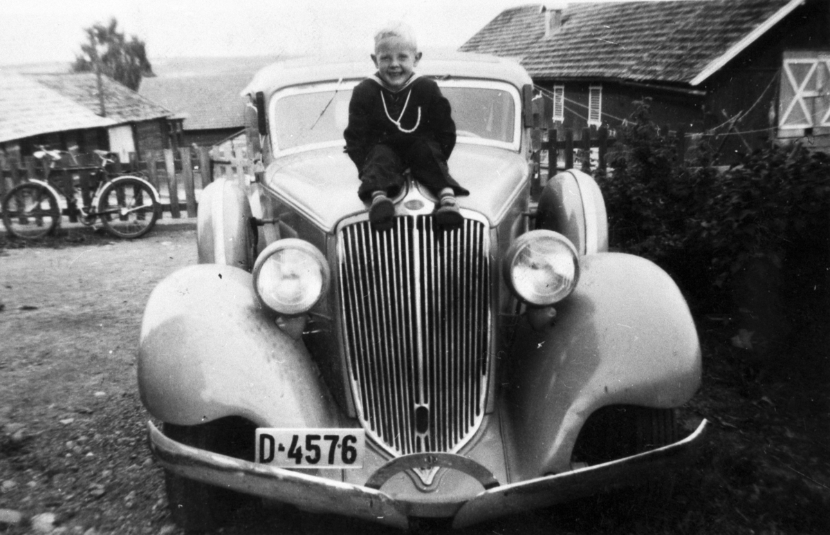 Bilen er en Graham 1932-34, personbil reg. nr. D-4576. Ukjent gutt siitende på bilens panser.