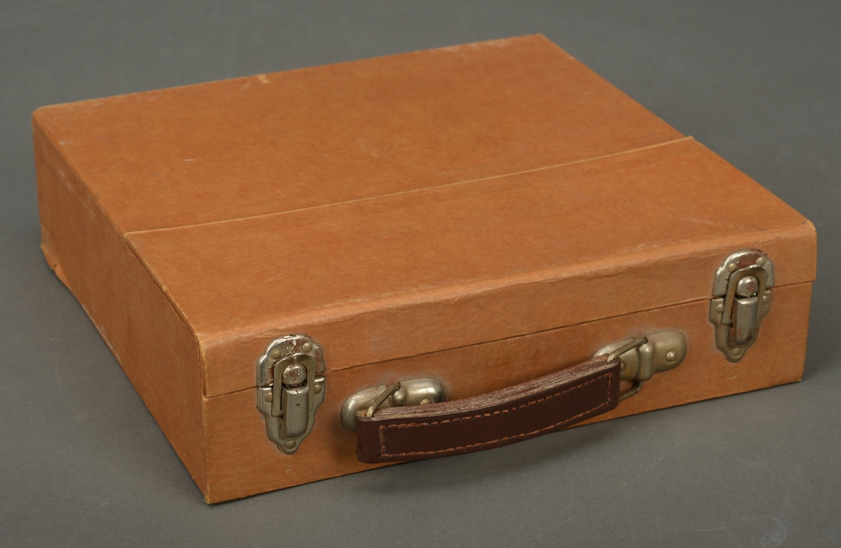 Koffert i brun hard papp, med håndtak i skinn og metall, og to låser. 15 LP- plater og to beskyttende papplater i kofferten. Franskkurs.