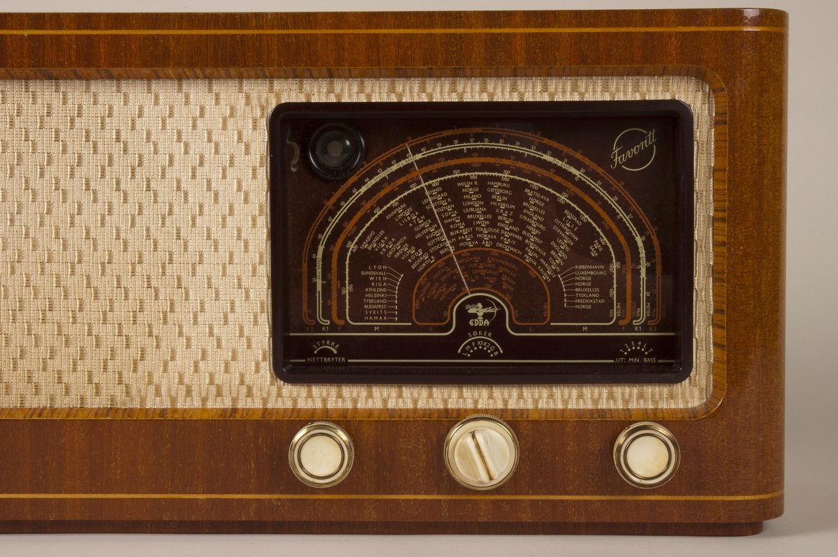 Radio med rørforsterker og integrert høyttaler i kabinett av lakkert mahogny. Lang-, mellom- og kortbølgefrekvenser. Utgang for eksterne høyttalere, båndopptak, antenne, jord og skjerm. Inngang for grammofon, båndavspilling og skjerm.