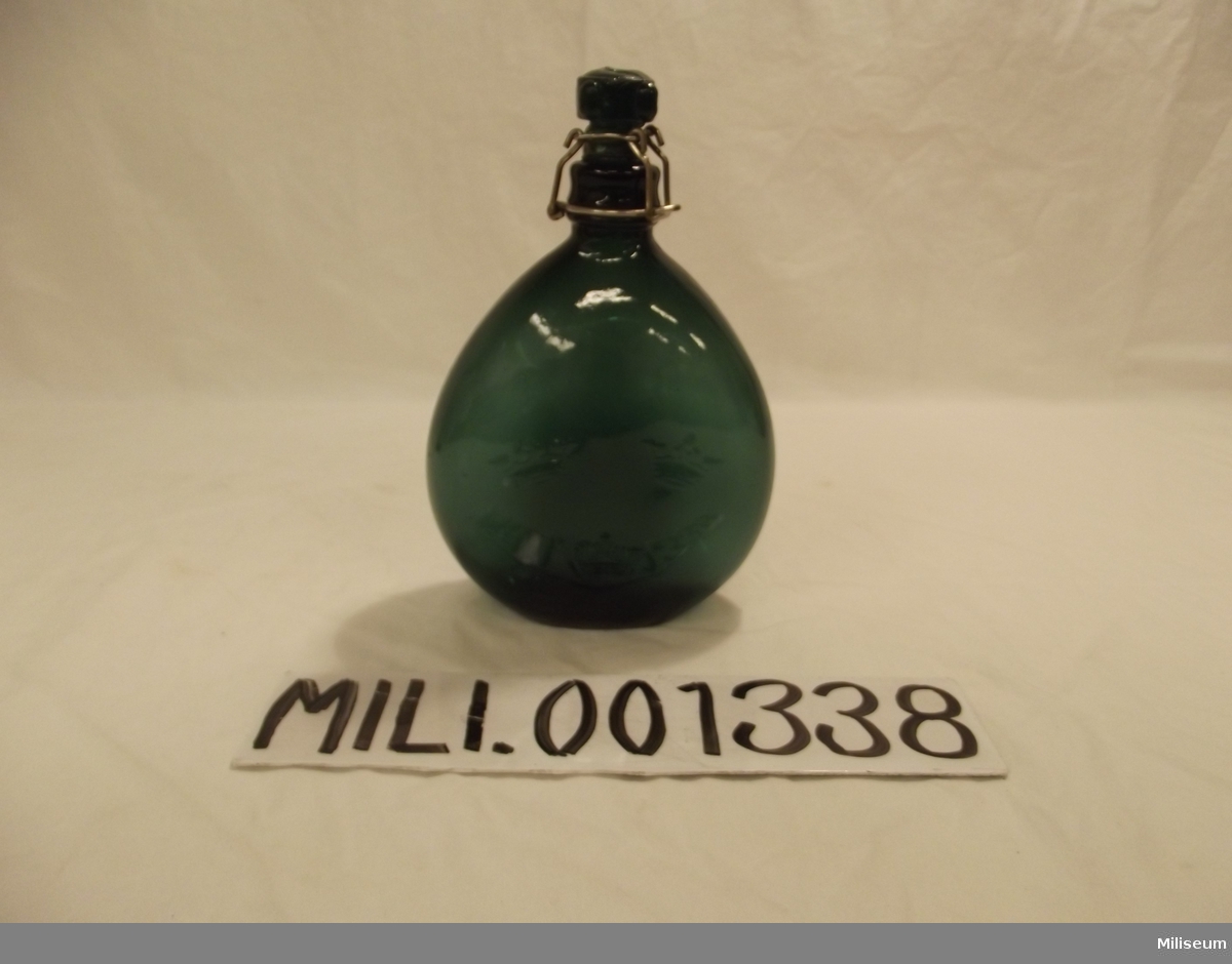 Dricksflaska m/1905 av grönt glas
Pluntmodell.
Med kork av glas.