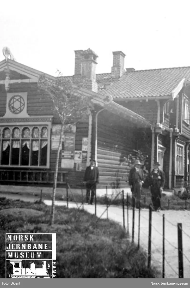 En samling menn utenfor Byglandsfjord stasjonsbygning