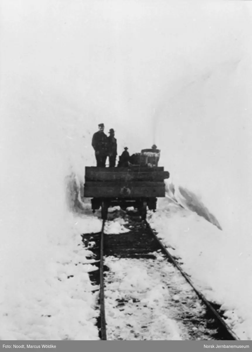Tog mellom høye brøytekanter på Arvedalslinjen (Kongens Grubes bane) pæl 600, sett i retning gruven