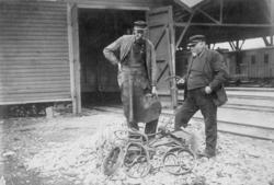 To mann inspiserer restene av en påkjørt håndtralle