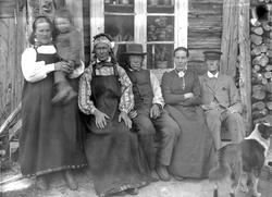 Gruppebilde av seks personer utenfor et gårdsbruk, trolig Ny