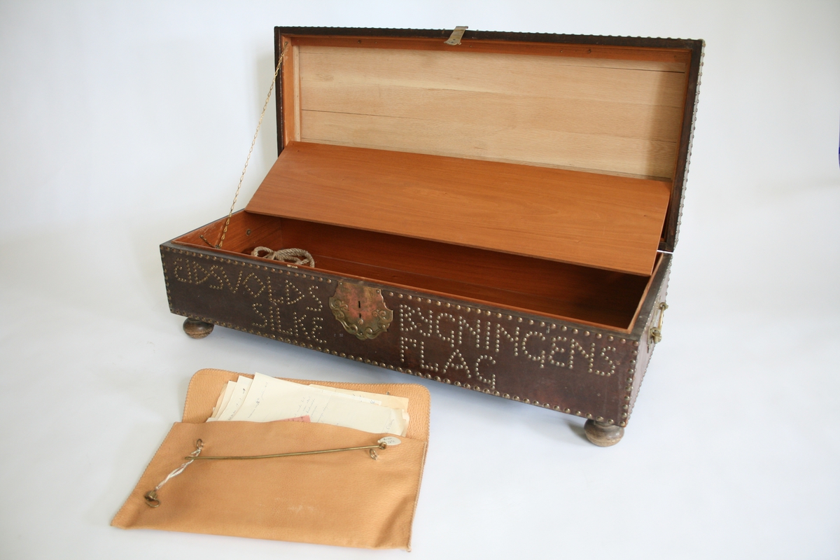 1 eketres kiste med kalveskinnstrekk, messingnagler og inskripsjon: "1814 Eidsvold 1914 " på lokket og " Eidsvoldsbygningens silkeflagg" på forsiden.