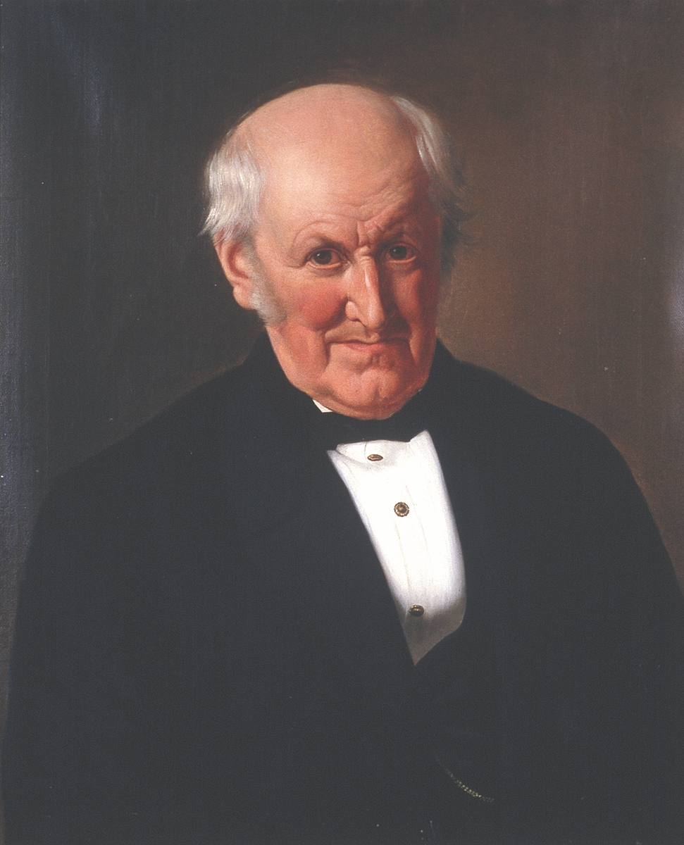 Portrett av Frederik Meltzer. Mørk drakt, hvitt skjortebryst. Rødbrun bakgrunn.