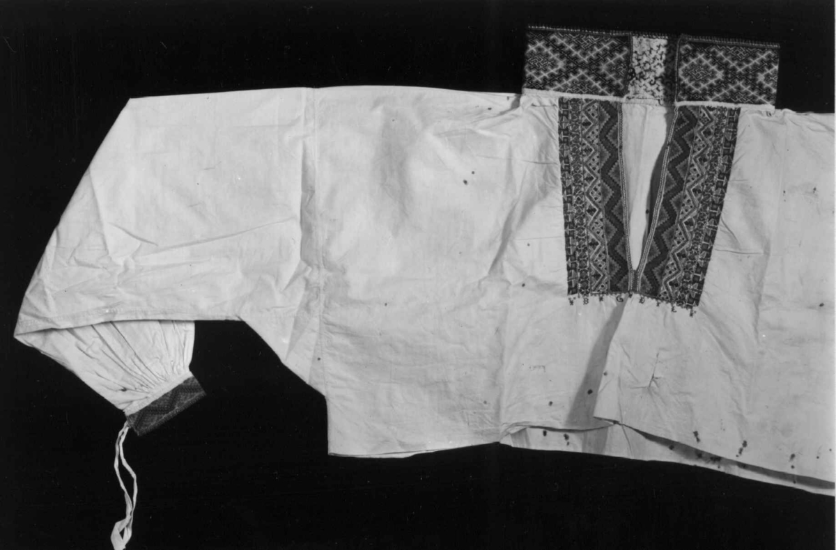Hvit skjorte til bunad med dekor av flerfarget broderi i ull.