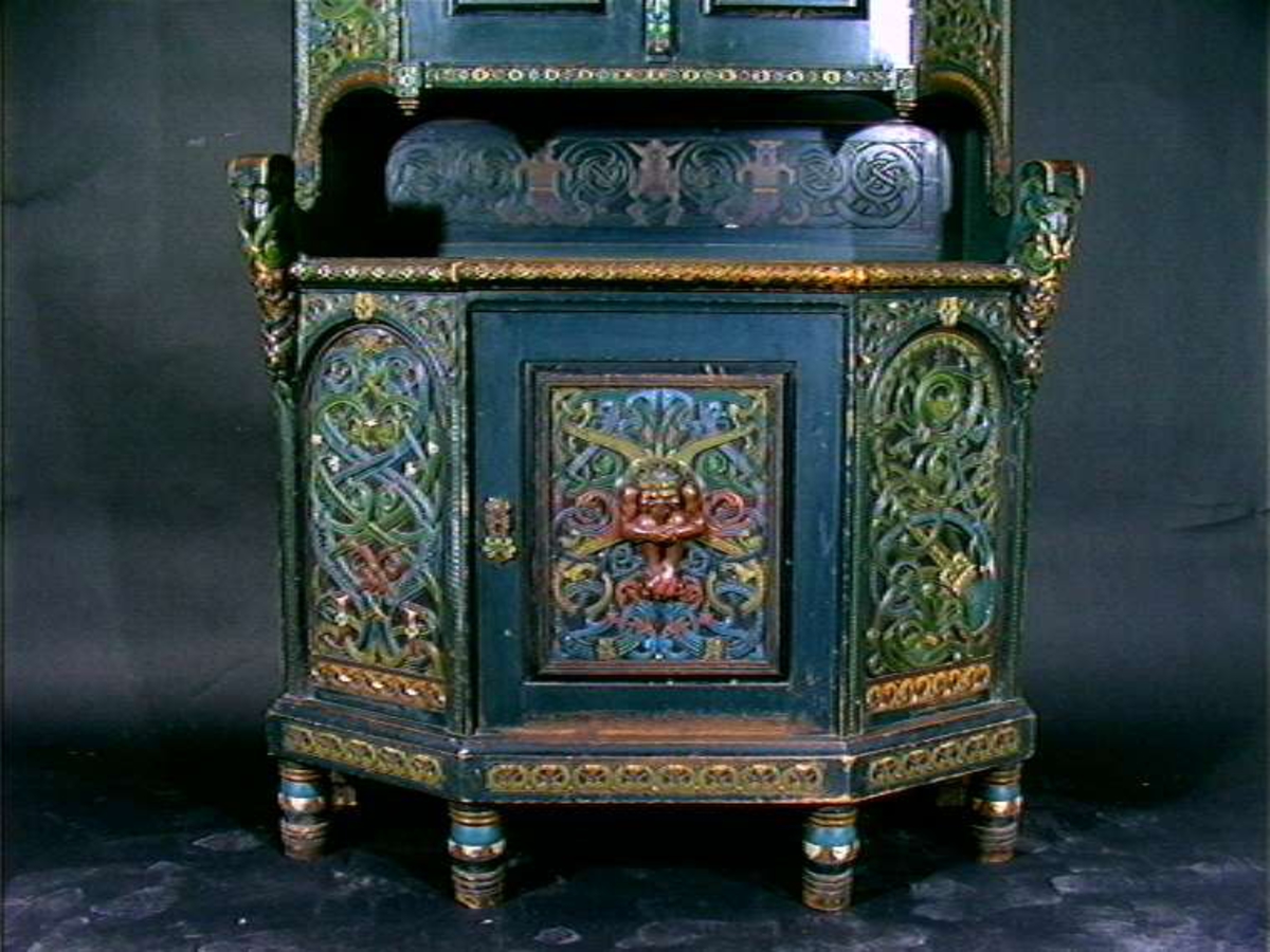 Skåret av treskjæreren Lars Kinsarvik (1846-1925), som utviklet sin særegne variant av drakestilen. Kinsarvik drev egen treskjærerskole, og var fra slutten av 1880-årene lærer ved Kristiania Kunstindustrimuseum.